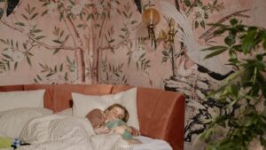 Femme qui dort dans une chambre avec des papiers peints sur le mur