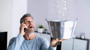homme avec une fuite d'eau chez lui